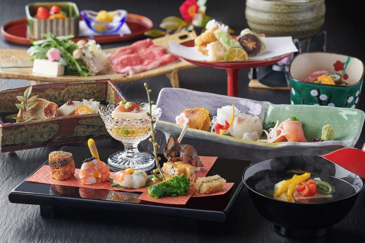 Ett urval av rätter på ett bord, inklusive sushi, sashimi och andra smårätter.