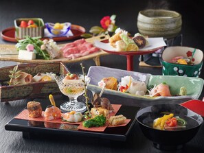 A variety of dishes on a table, including sushi, sashimi, and other appetizers. - Ryokan Beniayu (Nagahama)