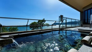 Una piscina infinita con vista despejada al mar y las montañas.