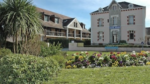 Un hôtel doté d’un balcon, d’un jardin fleuri et d’une enseigne indiquant « ROYAL BEARN ».