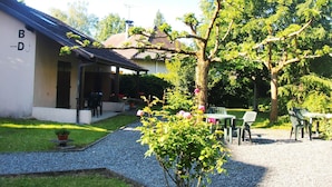 Une maison dotée d’un porche abrité, d’un chemin de gravier et d’un espace salon extérieur.