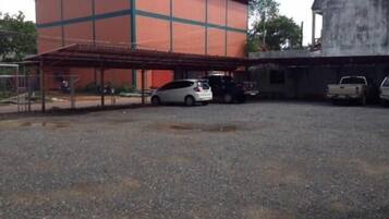 A building with a covered parking area and a gravel ground.
