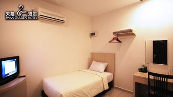 A hotel room with a bed, a TV, a desk, a chair, a mirror, and a coat rack.