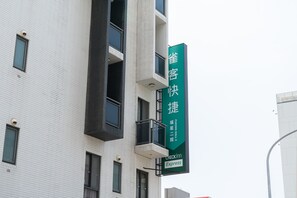 Un edificio con un cartel verde que indica un servicio de Check-in Express.