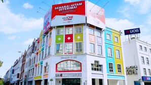 A colorful hotel building with multiple floors, a prominent red and white sign for Redone Postpaid, and a UOB sign on the right. - Hotel Zamburger Plaza Mahkota (Malacca City)