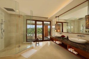 Une salle de bain moderne avec une douche à parois de verre, un grand miroir et un plan de toilette en marbre.
