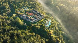 An aerial view of a resort with multiple buildings, a swimming pool, and lush greenery. - Padma Resort Ubud (Payangan)