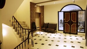 A spacious lobby with a marble floor, a staircase, and a reception area with a large arched doorway. - Hotel Delhi Darbar (New Delhi)