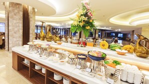Ein reichhaltiges Buffet mit verschiedenen Speisen und einer zentralen Blumenkomposition.