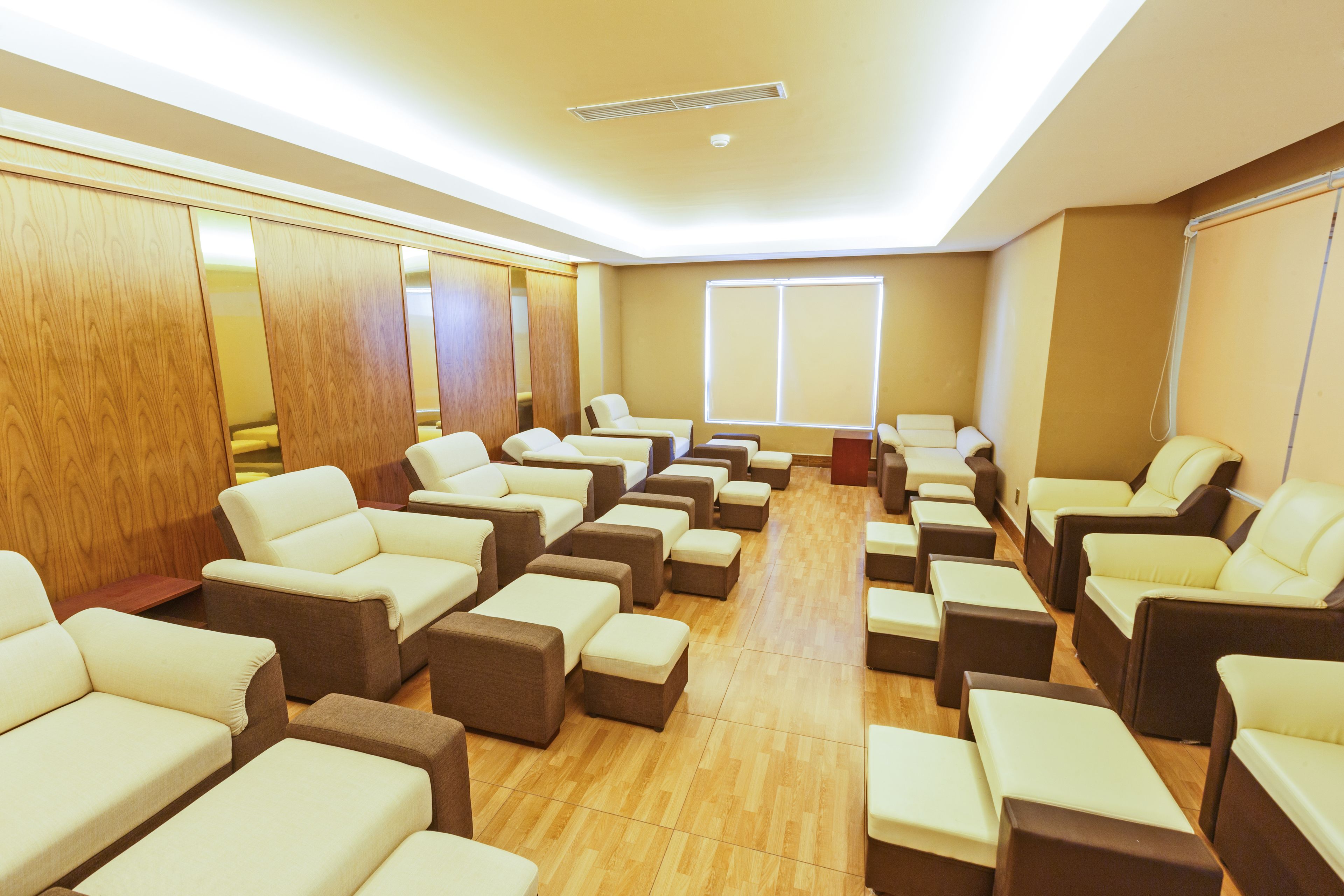 A room with multiple seating areas, including sofas and chairs, arranged in a spacious layout.