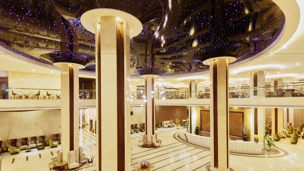 Eine geräumige Lobby mit hohen Decken, großen Säulen und modernem Design.
