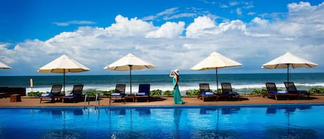 Piscine extérieure, parasols de plage, chaises longues