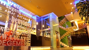 A modern interior with a bar area, a staircase, and a large clock on the wall. - Agua de Mar Hotel Boutique (Vigo)