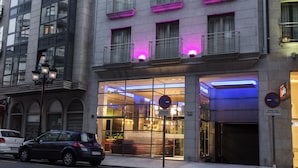 A modern building with large windows and a glass entrance. - Agua de Mar Hotel Boutique (Vigo)
