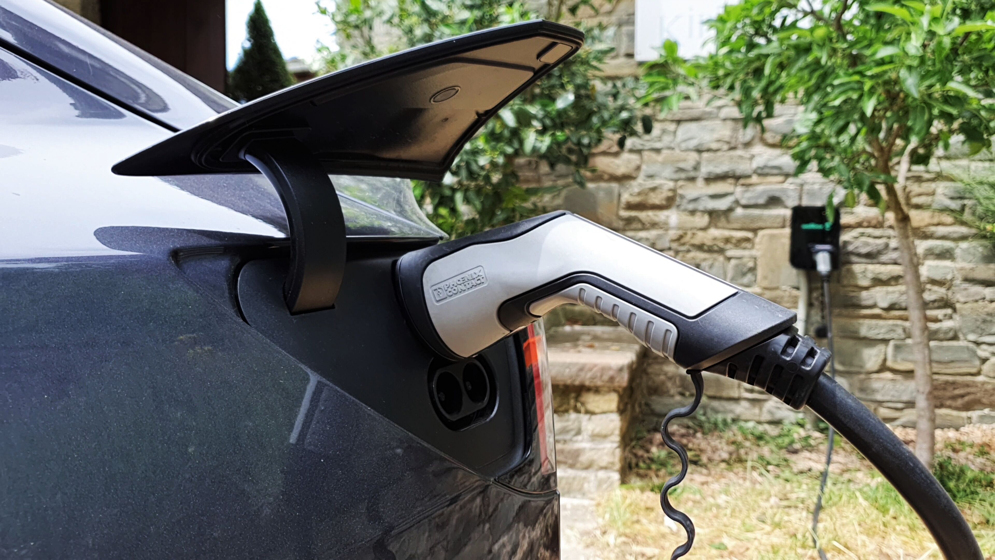 Une voiture dotée d’une borne de recharge fixée sur le côté.