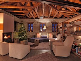 Una sala de estar acogedora con chimenea, un árbol de Navidad y una pared de piedra.