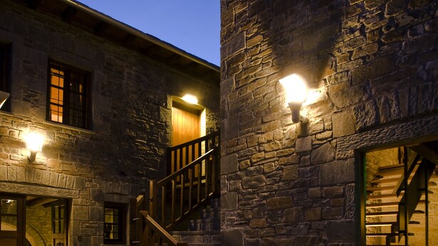 A stone building with a staircase and a wooden railing. - Kipi Suites (Zagori)