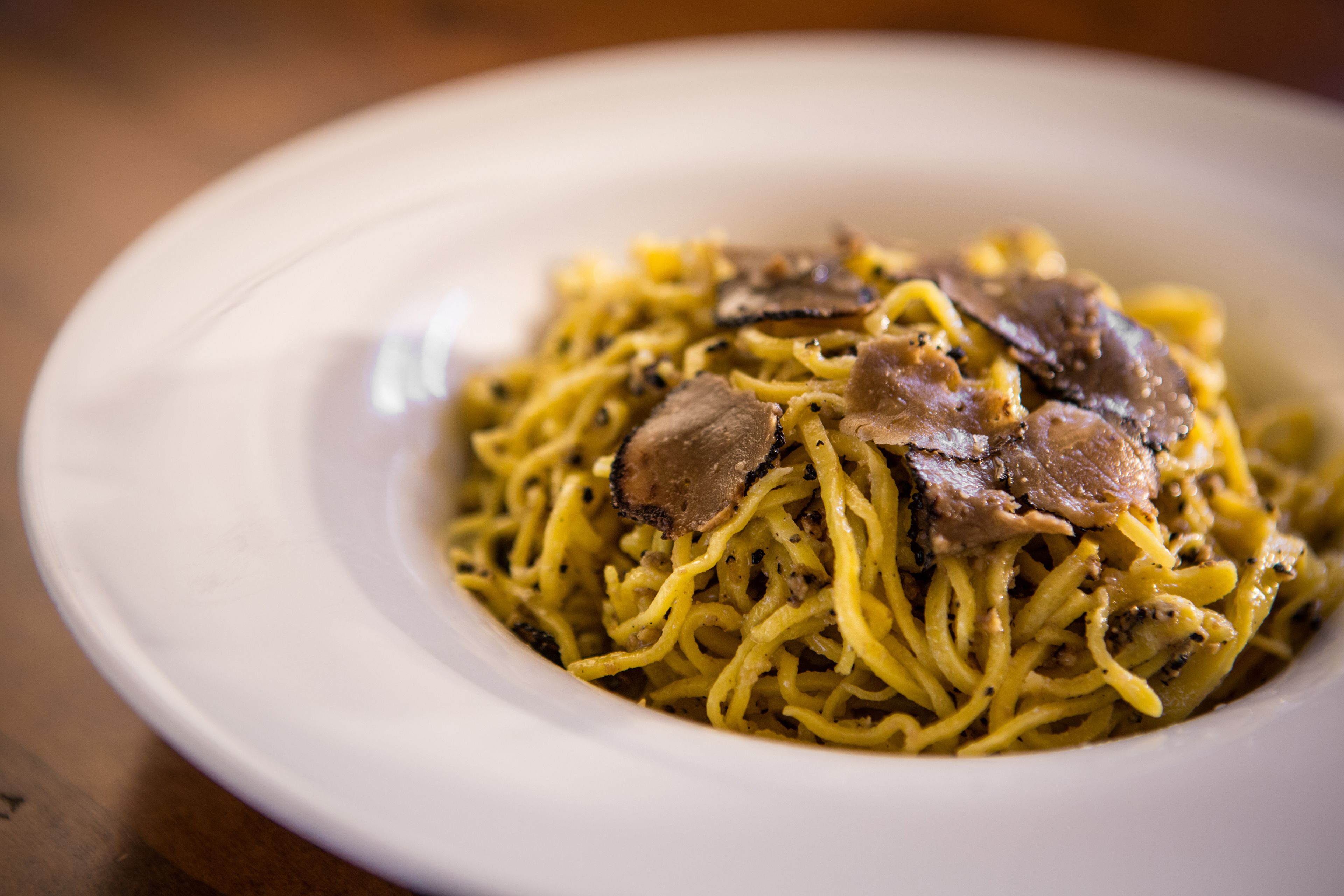 A bowl of pasta with mushrooms and meat.