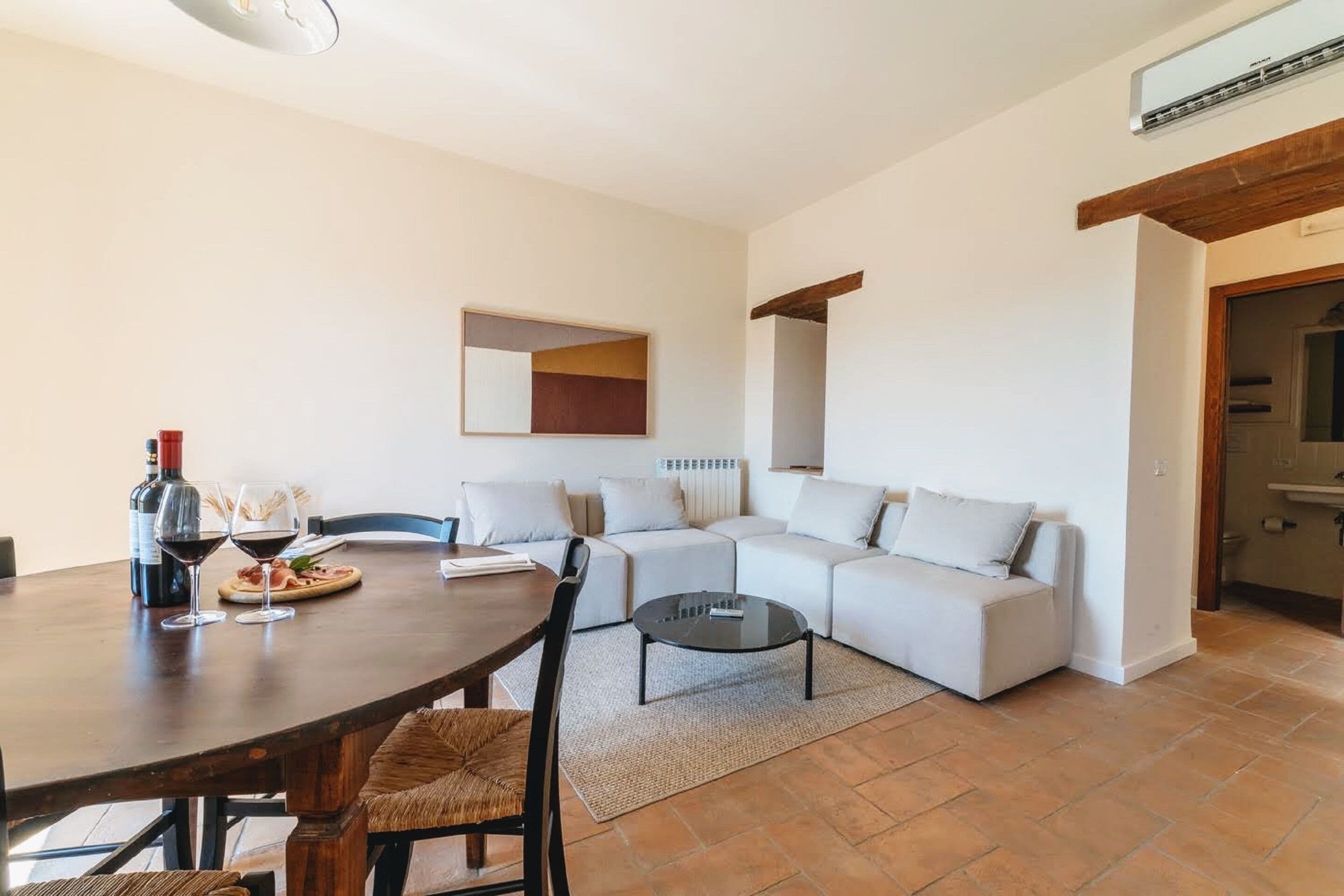 A modern living room with a dining table, sofa set, and a coffee table.