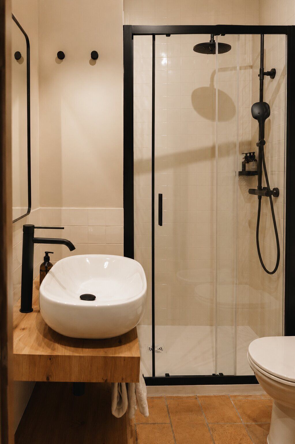 A modern bathroom with a glass-enclosed shower, a white sink, and a toilet.