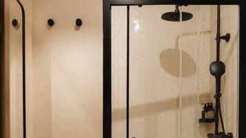 A modern bathroom with a glass-enclosed shower, a white sink, and a toilet.