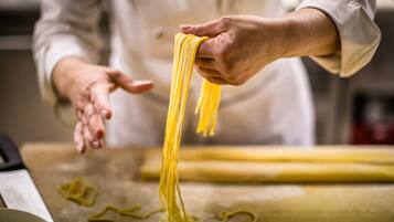 Una persona preparando pasta sobre una superficie de madera.