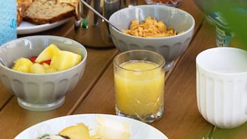A breakfast table with various food items, including toast, cereal, fruit, and a glass of orange juice.