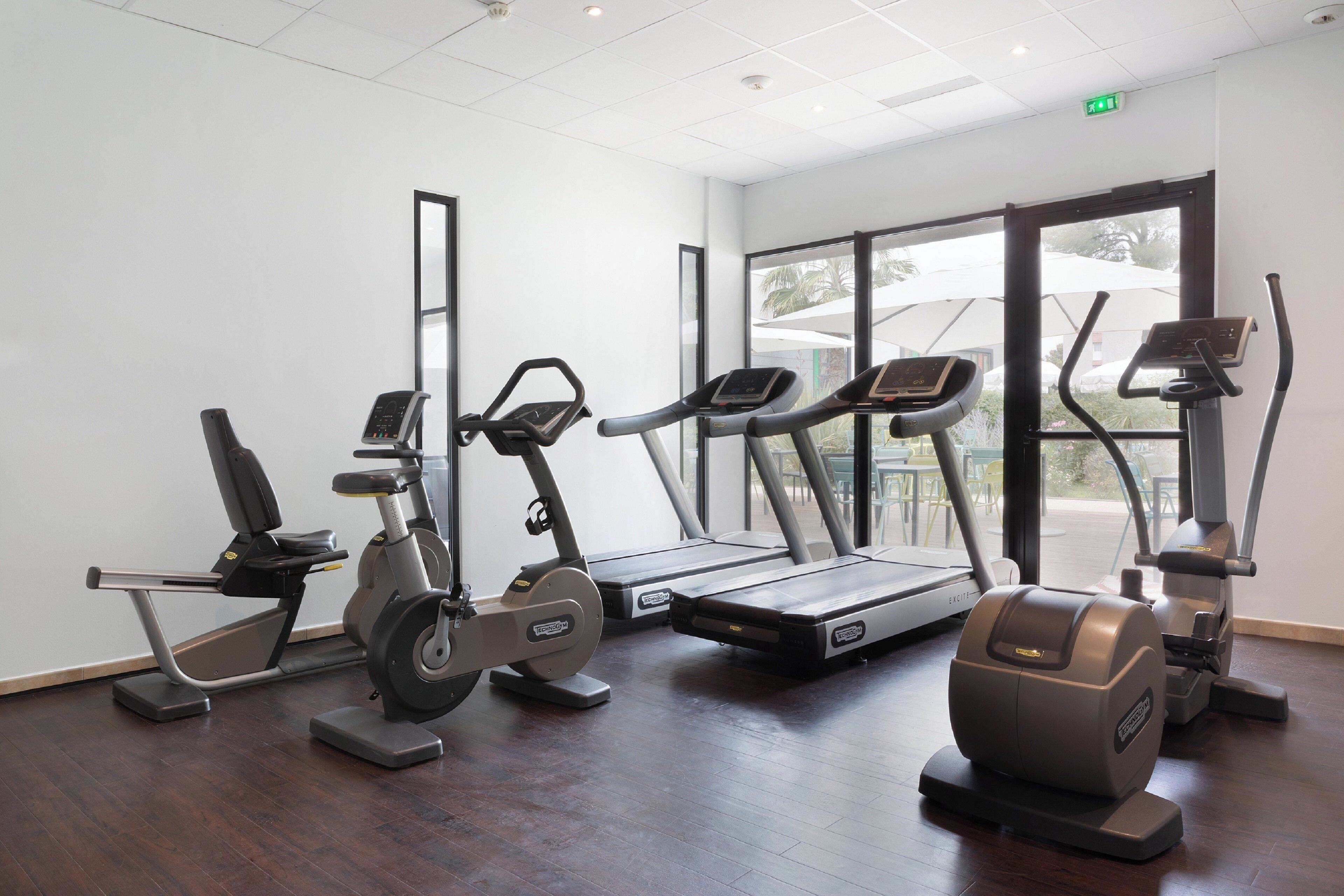 A fitness center with various exercise equipment including treadmills, an elliptical, and a stationary bike.