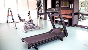 Ein Fitnessstudio mit Laufbändern, Crosstrainern und Rudergeräten.