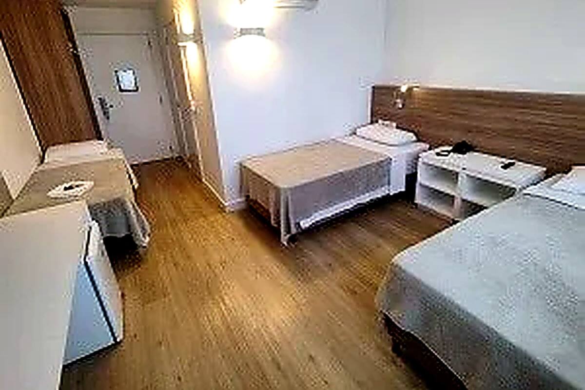 Una habitación de hotel compacta con una cama individual, una mesita de noche, un escritorio pequeño y un armario.