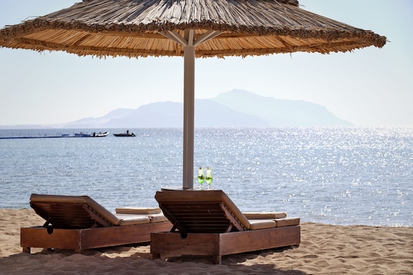 On the beach, white sand, sun loungers, beach umbrellas