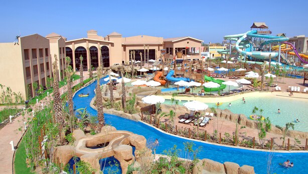Un resort con una piscina grande, toboganes de agua y parque acuático.