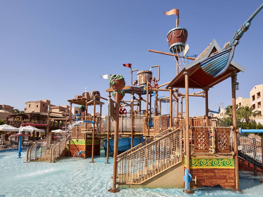 A water park with a pirate-themed play structure, including slides and climbing areas.