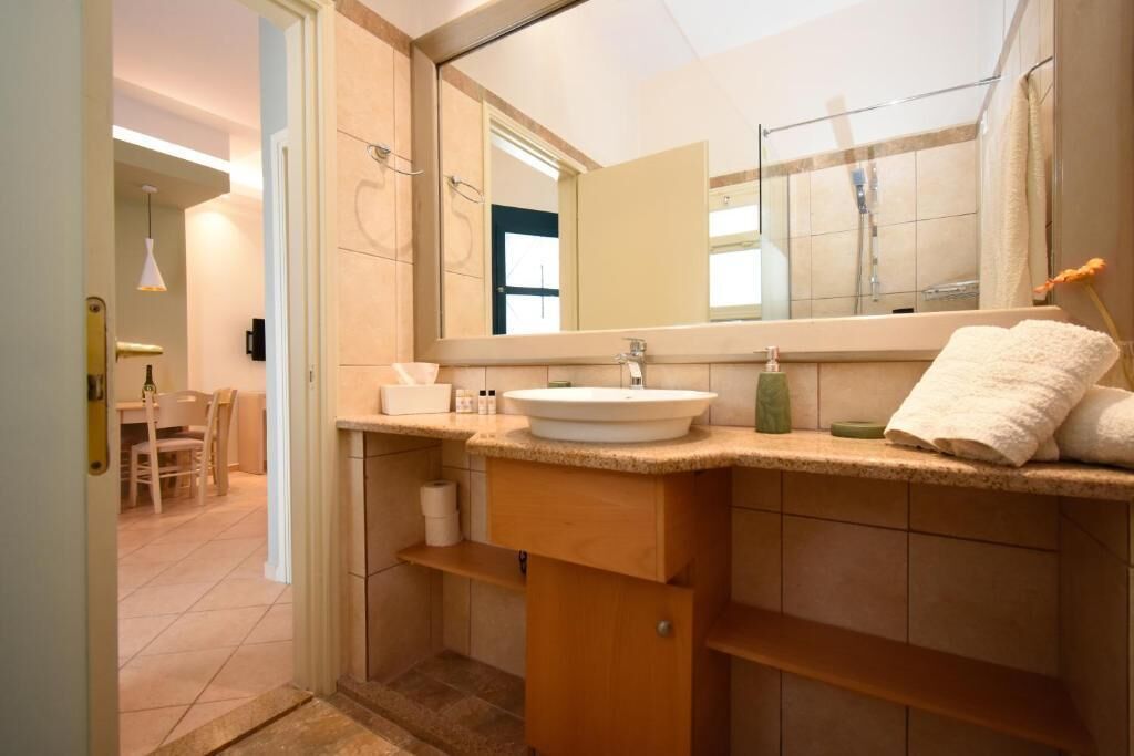 Een moderne badkamer met een grote spiegel, een wastafel en een handdoekrek.