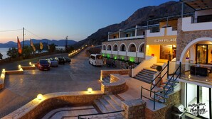 A building named 'ELENA VILLAGE' with a stone facade, multiple balconies, and a staircase leading to an upper level. - Elena Village (Kalymnos)