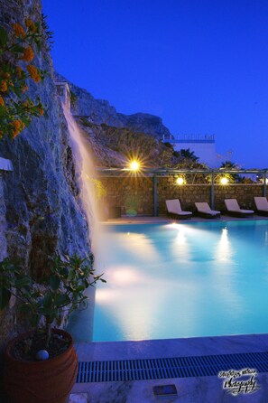 Una piscina al aire libre, tumbonas