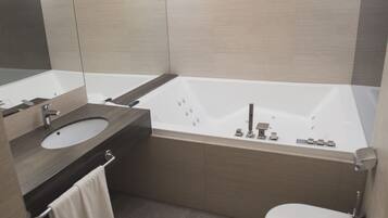 Un bagno moderno con vasca, lavabo e water.