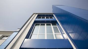 Ein modernes Gebäude mit einer markanten blauen Fassade und großen Fenstern.