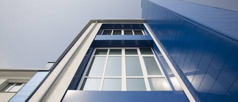A modern building with a prominent blue facade and large windows.