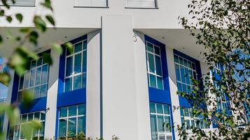 Un hotel moderno con una segnaletica ben visibile che riporta "MHOTEL DIAMANTE" e ampie finestre.