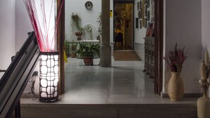 A staircase leading to a room with a view of a garden and a door to another room. - El Granado Hostel (Granada)
