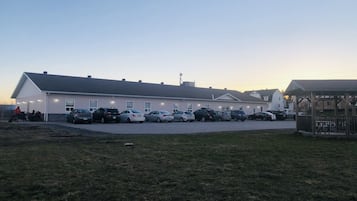 Vista frontal de la propiedad por la tarde o noche