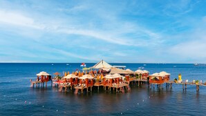 Un hôtel situé au bord de l’eau, doté d’espaces extérieurs aménagés et offrant une vue sur la mer.