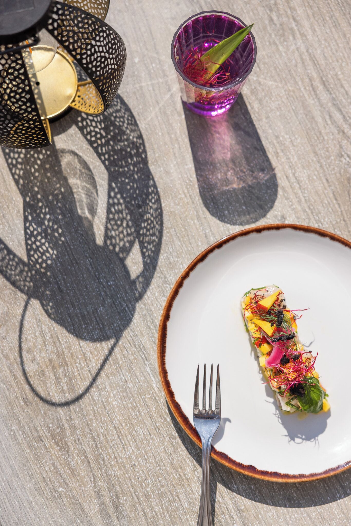 Une table avec une assiette de nourriture, un verre et des objets décoratifs.