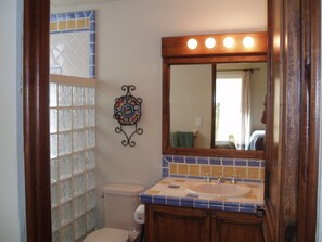 A bathroom with a toilet, sink, and mirror. - Cabo Vista (Cabo San Lucas)