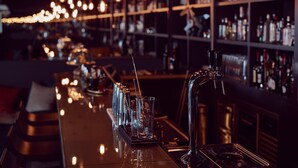 A bar area with a long counter, multiple glasses, and a tap. - Hôtel de Cavoye (Fontainebleau)