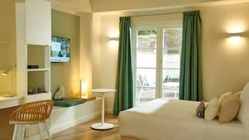 A hotel room with a bed, a desk, a chair, a TV, and a view of the outside.