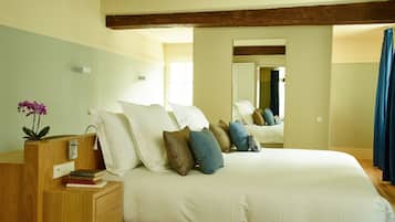 A bedroom with a large bed, wooden headboard, bedside tables, and a mirror.