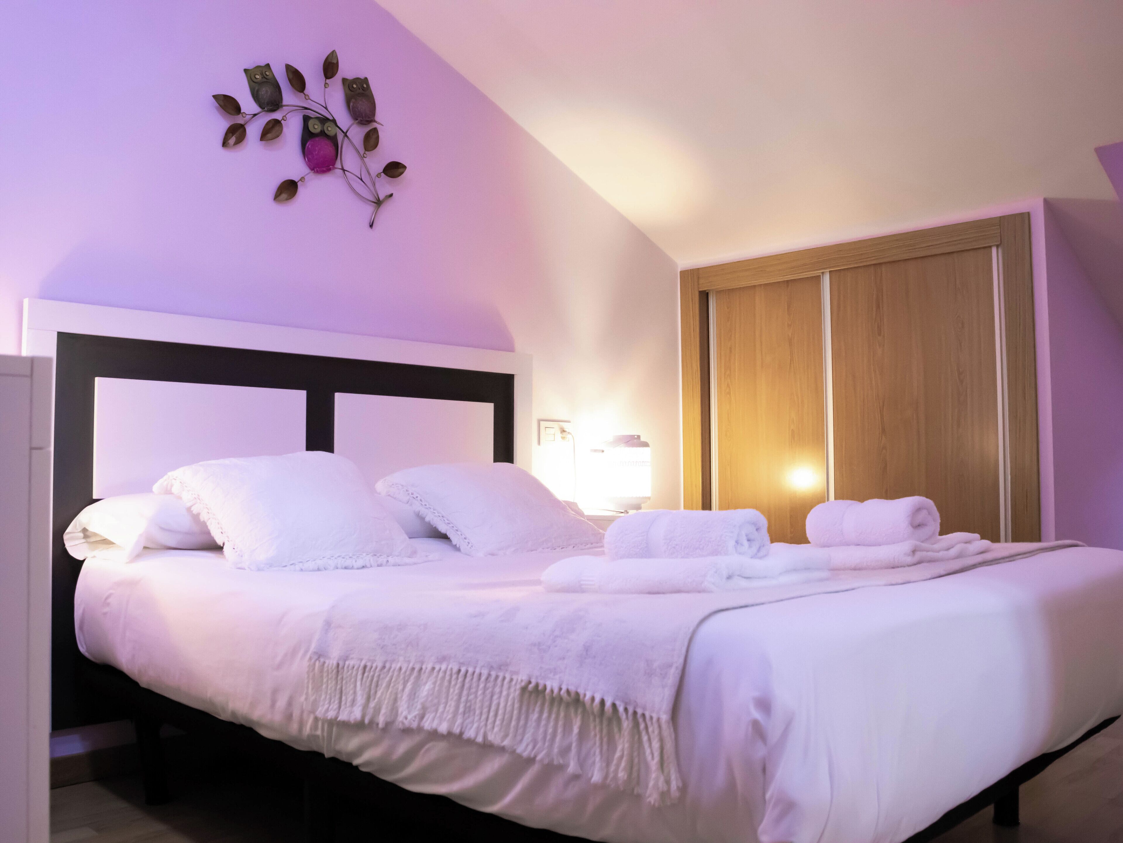 Una cama bien hecha con sábanas blancas y un adorno decorativo encima.