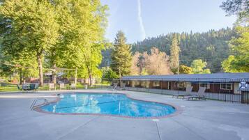 Relax by the serene pool surrounded by lounge chairs and lush greenery.